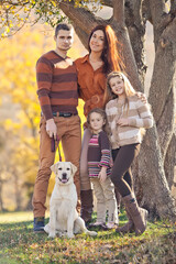 Fototapeta premium Family resting in nature in autumn. Beautiful woman with a man have fun playing with children. High quality photo.