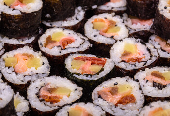 Top view of stack of Japanese sushi maki roll plate. Served in Japanese bar restaurant with chopstick