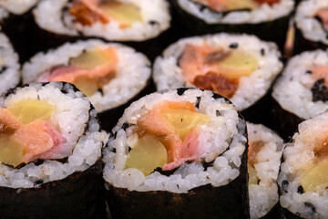 Top view of stack of Japanese sushi maki roll plate. Served in Japanese bar restaurant with chopstick
