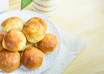 Fresh bun, kitchen utensils and eggs on wooden background, homemade bakery