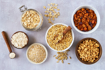 Oat products assortment in bowls. Granola, rolled oats, bran , flour and raw oat seeds . Top view