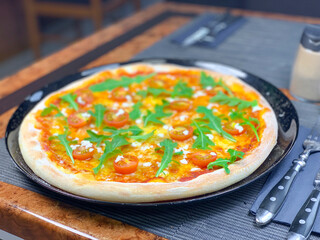 Pizza mit Cherrytomaten und Rucola