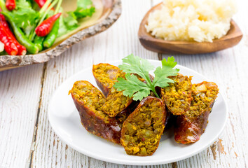 Thai northern herb sausage sliced on white dish on table with copy space for your text. Thai food concept.