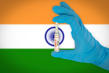 New coronavirus vaccine with the flag of India in the background. India medical research and vaccine development center. Doctor holding coronavirus vaccine in his hand.