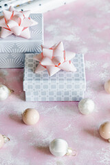 Christmas and New Year holiday background or greeting card. Gray white gift boxes with pink bows. 