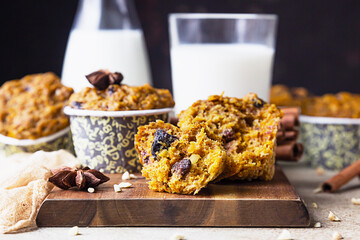 Fall pumpkin or carrot healthy vegan soft muffins with milk, light concrete background.
