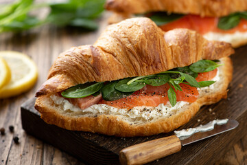 sandwich with salmon, spinach and cream cheese on a wooden board, selective focus, close-up