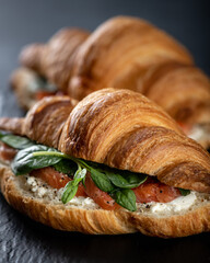 sandwich with salmon, cream cheese and spinach on black background, selective focus, close-up
