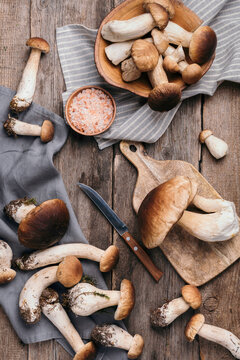 Picked Porcini mushrooms in basket. Autumn harvest concept. Fresh forest boletus mushrooms on wooden background. Top view. Copy space