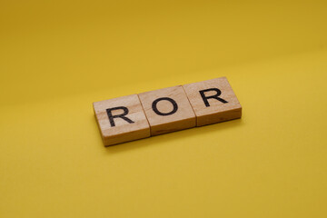 ROR Word Written In Wooden Cube With Yellow Background