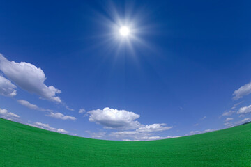 緑の草原と雲と太陽
