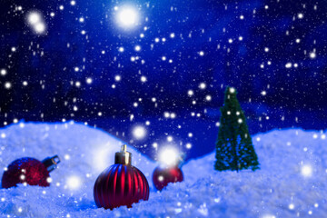 Christmas background with Christmas balls on snow over fir-tree, night sky and moon. Shallow depth of field. Christmas background. Fairy tale. Macro. Artificial magic dreamy world.