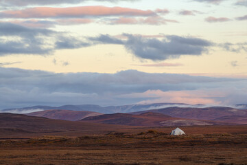 Picturesque autumn arctic landscape. Yaranga of reindeer herders in the tundra (tent-like traditional mobile home of the Chukchi). Beautiful nature of Chukotka and polar Siberia. Far North of Russia.