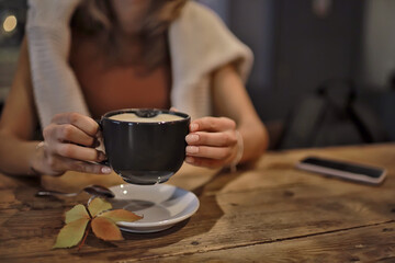 cup of cappuccino in a cafe in hands, coffee in a restaurant interior
