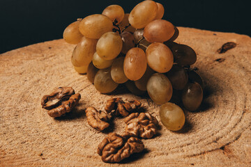 Table white grapes and wanlnuts on wooden table. High quality photo