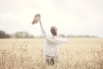 happy girl in autumn field with spikelets landscape / adult young girl portrait, summer look, nature