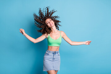 Photo of shiny funky festive bright lady model spinning curly hair whirl wind round wheel shape adventures camp center advert wear green top denim skirt isolated pastel blue color background