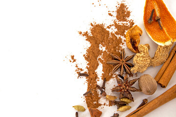 christmas spices, cinnamon powder, cinnamon sticks, anise stars, allspice,  dry orange peel on white background