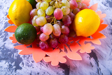 Bunch of grapes,lemon,orange,lime in a vase on a black and white background, close-up,with space for text,background,postcard,Wallpaper,