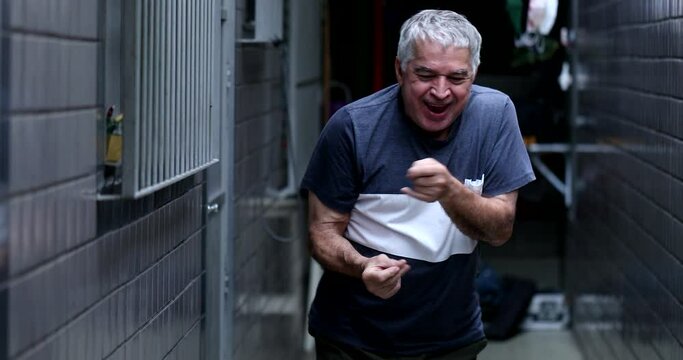 Casual old man doing funny funky dance. Senior celebrating success