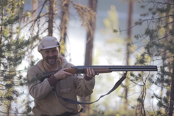 Fototapeta premium man goes hunting forest summer / landscape in the forest, huntsman with a hunting rifle hunts