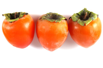Three fresh ripe persimmon fruit isolated on white background