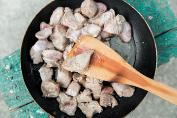 fried beef in a pan. roast beef cooking process. top view. simple rural dishes. close-up view