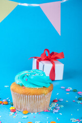 Cupcake with present gift on blue