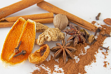 anise, cinnamon, orange peel, dried ginger, clove, nutmeg on white background