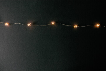 Christmas holidays lights garland star shape decoration on black background