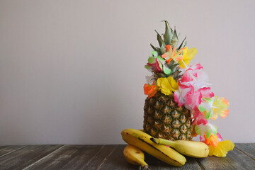 Decorative Pineapple with Bananas and Flowers on a Wooden Table