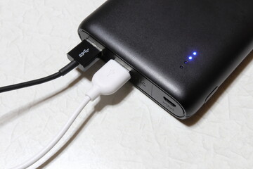 Black mobile battery and cable / 黒いモバイルバッテリー(ケーブル付き)(アップ)