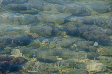 Sea floor with pebbles underwater. Pure water.