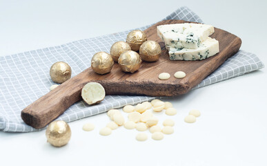 chocolate truffles made from white chocolate and dor blue cheese on a wooden board