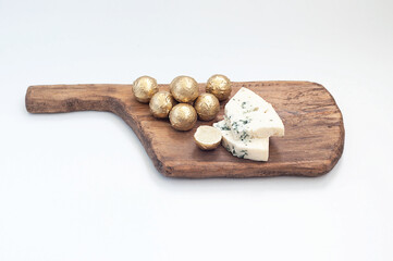 chocolate truffles made from white chocolate and dor blue cheese on a wooden board
