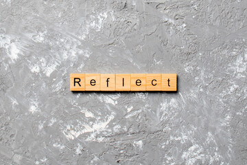 Reflect word written on wood block. Reflect text on table, concept