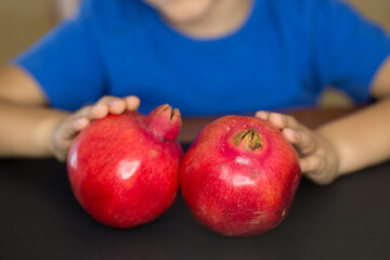 Child holding Two pomegranates
