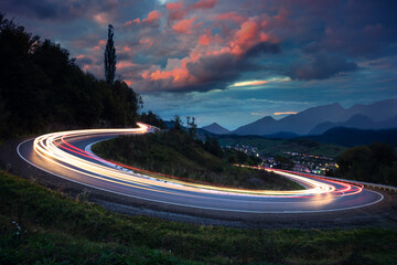 Long exposure - Lights on the asphalt, at night on a mountain road - 385477536