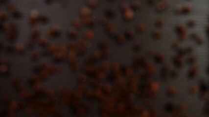Beautiful aromatic coffee beans on a black background. Super slow motion. Macro