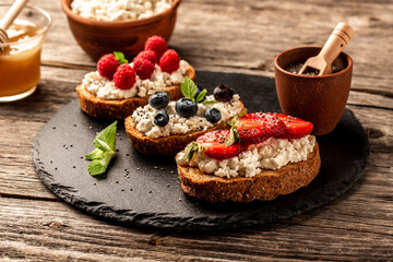 Traditional American and European summer breakfast: sandwiches of toast with cheese ricotta blueberries, strawberries, raspberries