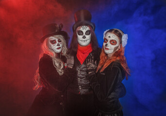 Beautiful group of three people with creepy Halloween make up dead day calavera style