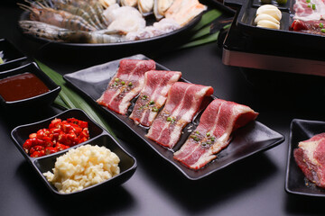 Raw beef slice for barbecue japanese style, yakiniku. Meats are being cooked on stove.