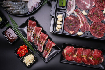 Raw beef slice for barbecue japanese style, yakiniku. Meats are being cooked on stove.