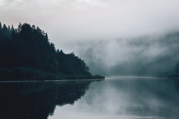 A village in a misty landscape in the early morning, Russia.
