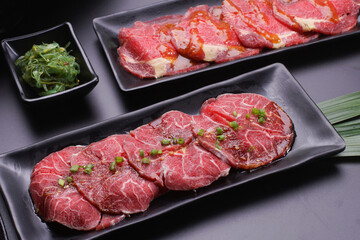 Raw beef slice for barbecue japanese style, yakiniku, meat are being cooked on stove.