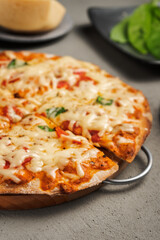 Vegetarian pizza near the ingredients on the concrete surface. Close up