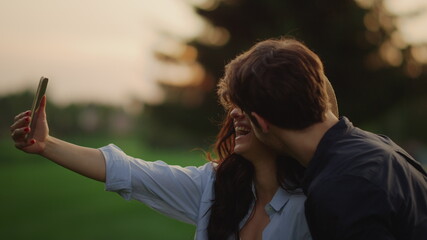Yonug couple having video chat online on mobile phone at meadow