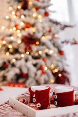 white cups in a knitted case in red in Christmas decor
