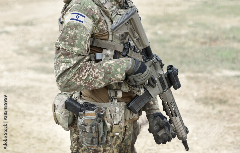 Wall mural Soldier with assault rifle and flag of Israel on military uniform. Collage.