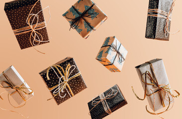 Christmas gift boxes falling or flying in motion on beige background.